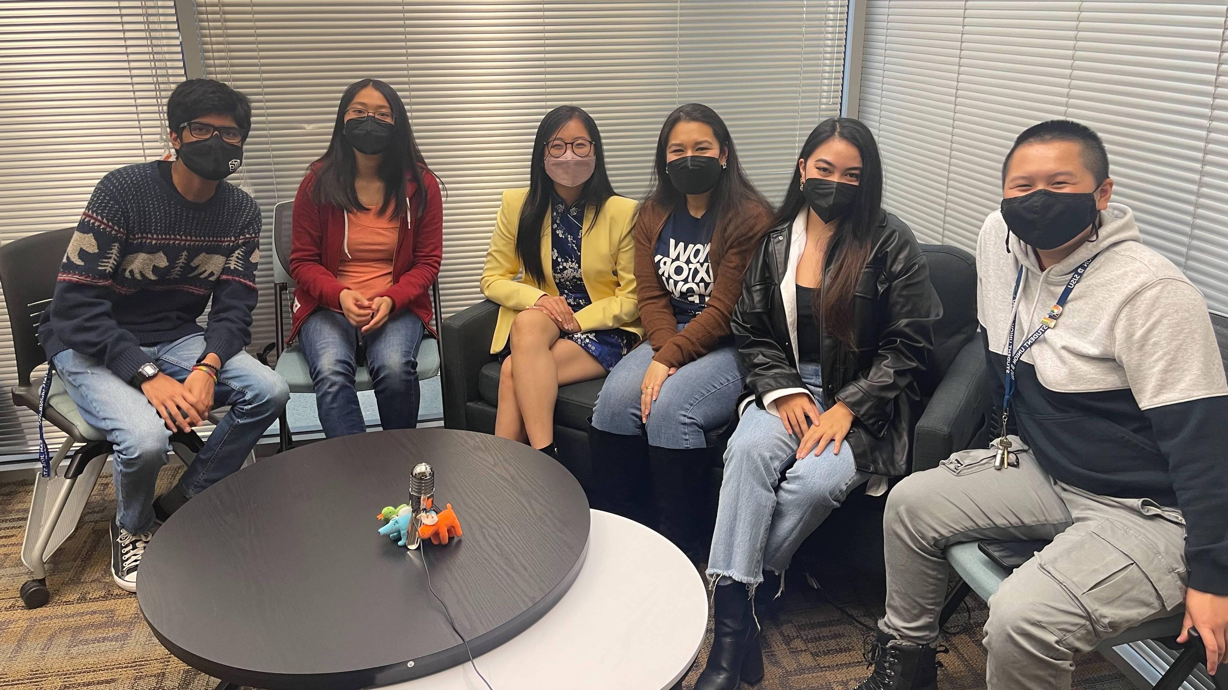 Students and staff sitting on a couch.