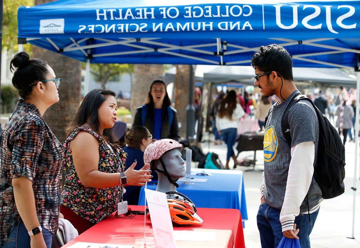 Student visiting a health fair booth and getting information.