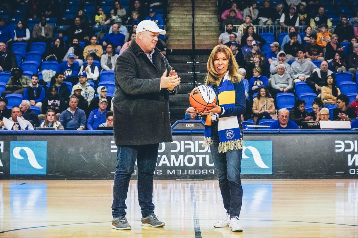 The president holding a basketball and standing next to Jeff Konya.